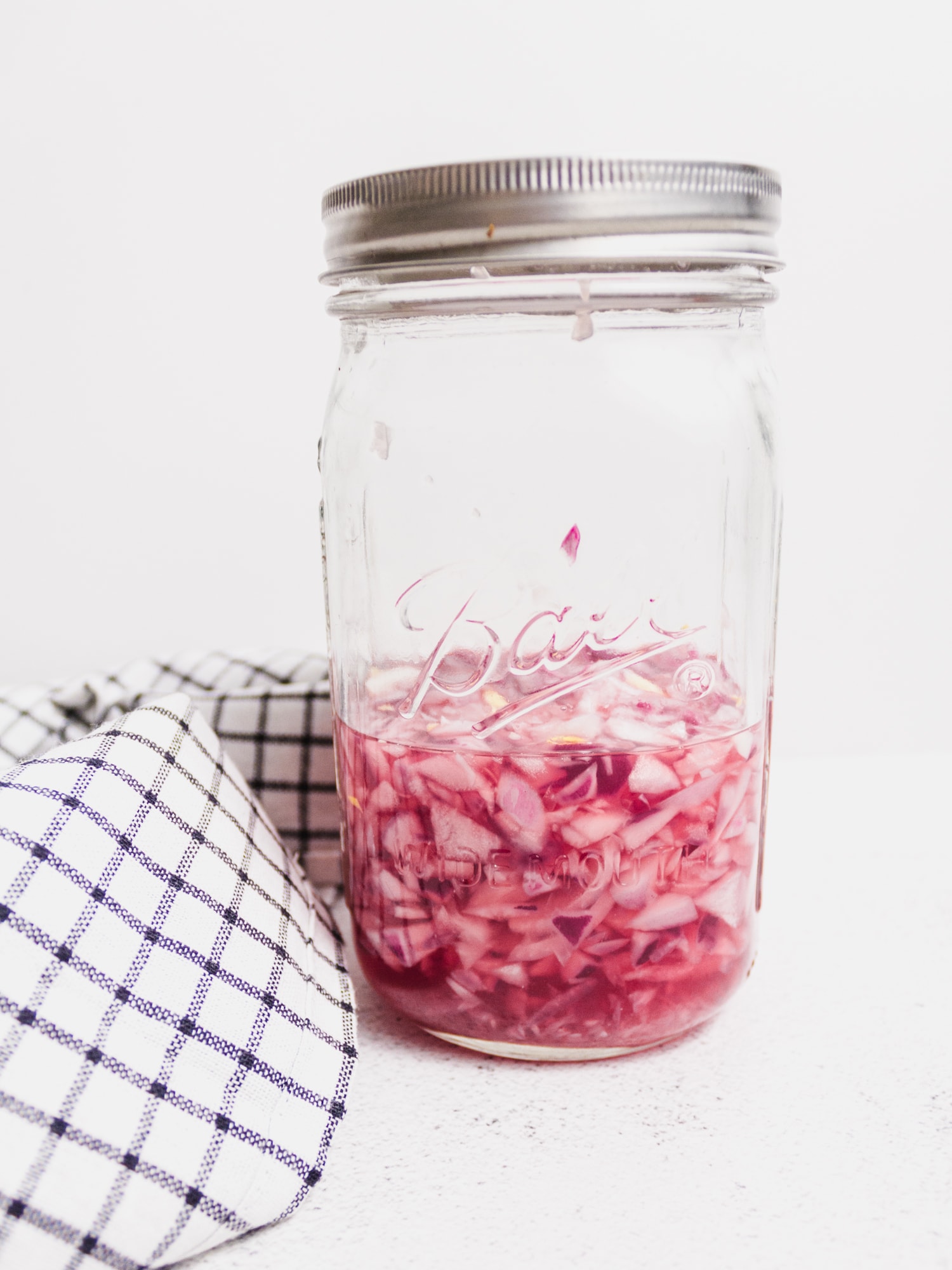 Pink pickled onions in mason jar.