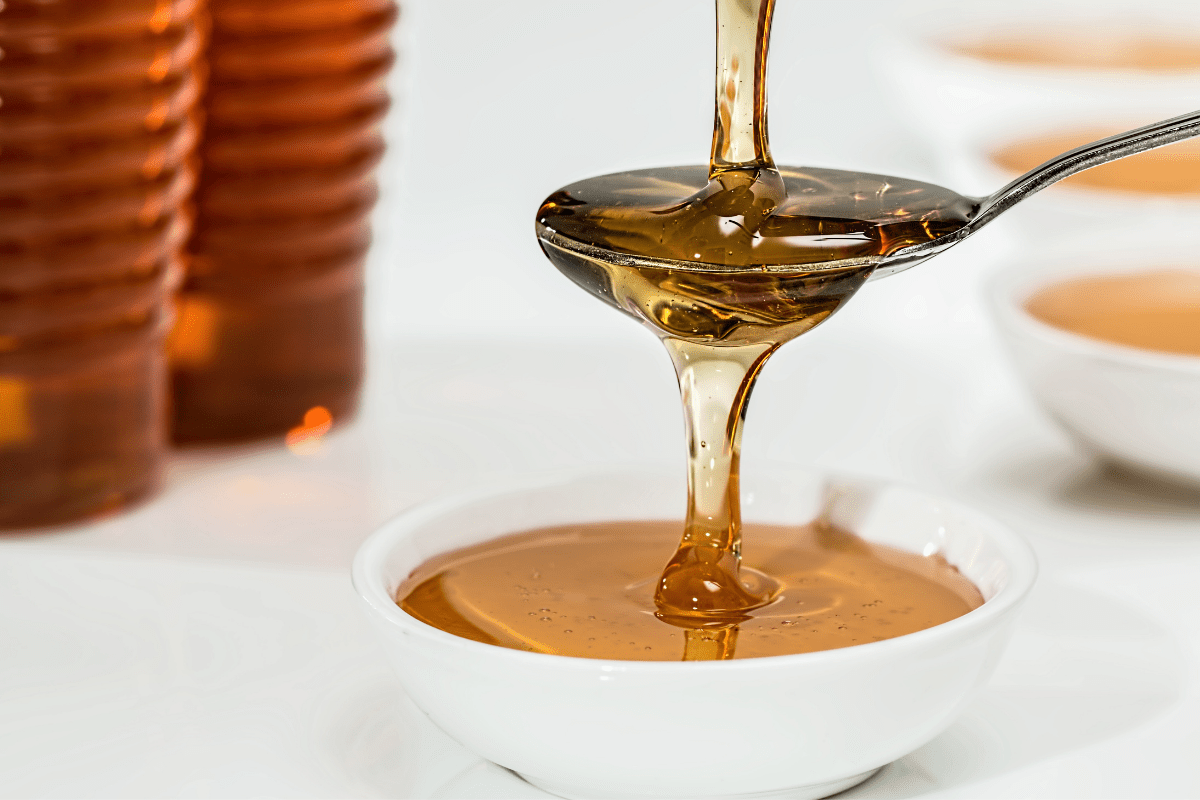 Honey drizzling into a spoon.