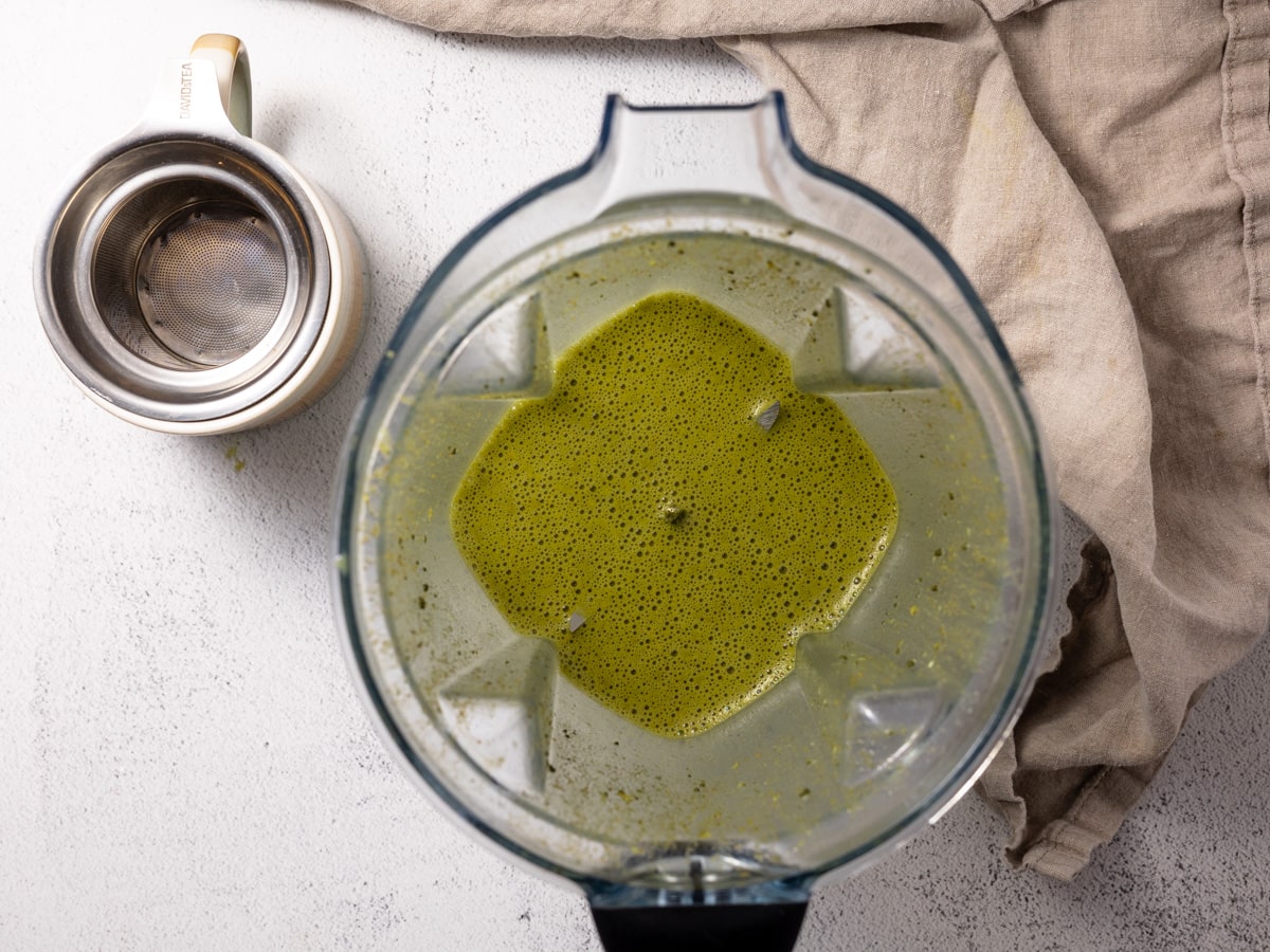 A blended matcha turmeric latte. It's still in the vitamix blender with an empty cup by its side. 