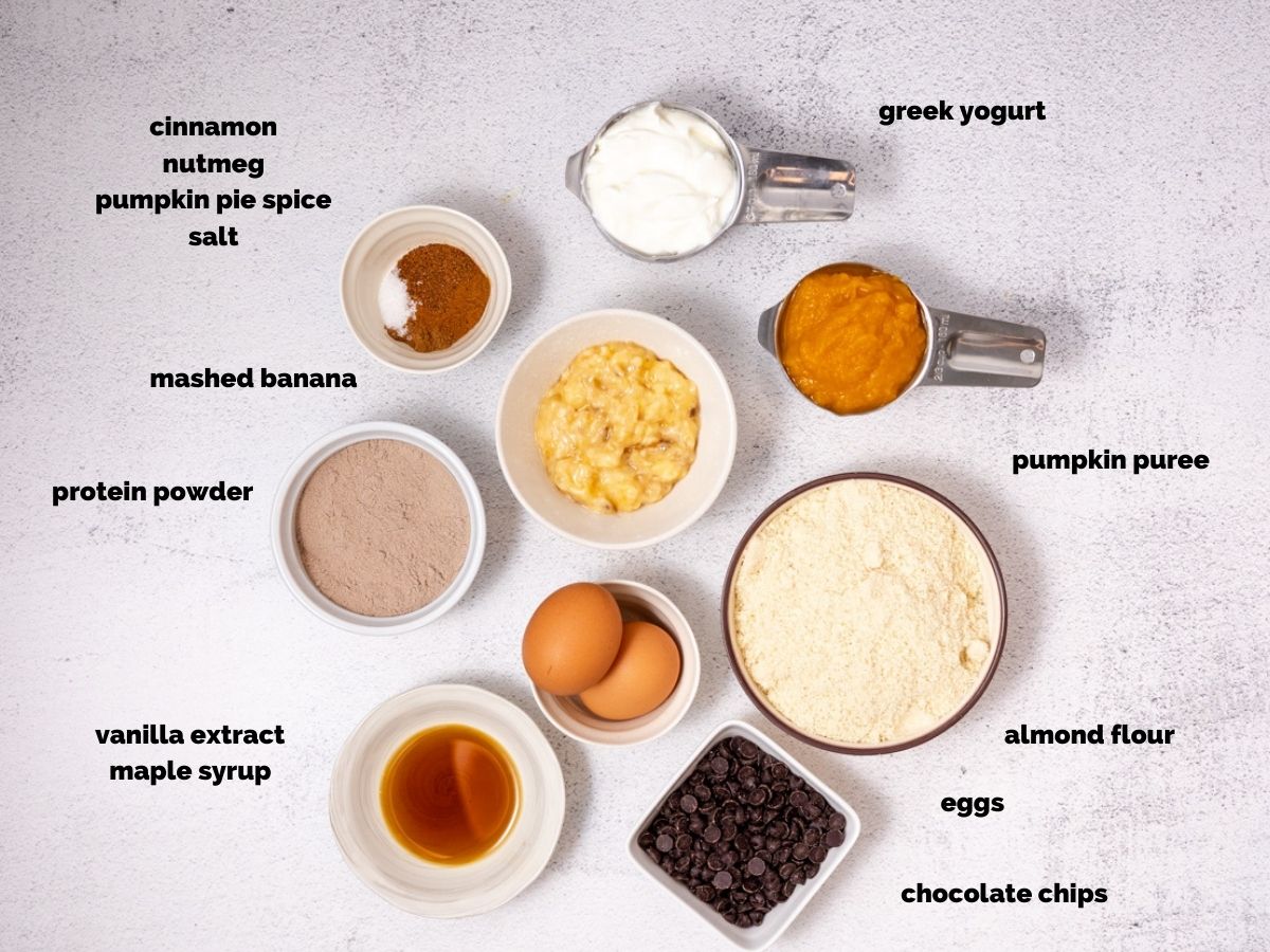 Ingredients needed to make pumpkin protein muffins. Shot from overhead on white counter.