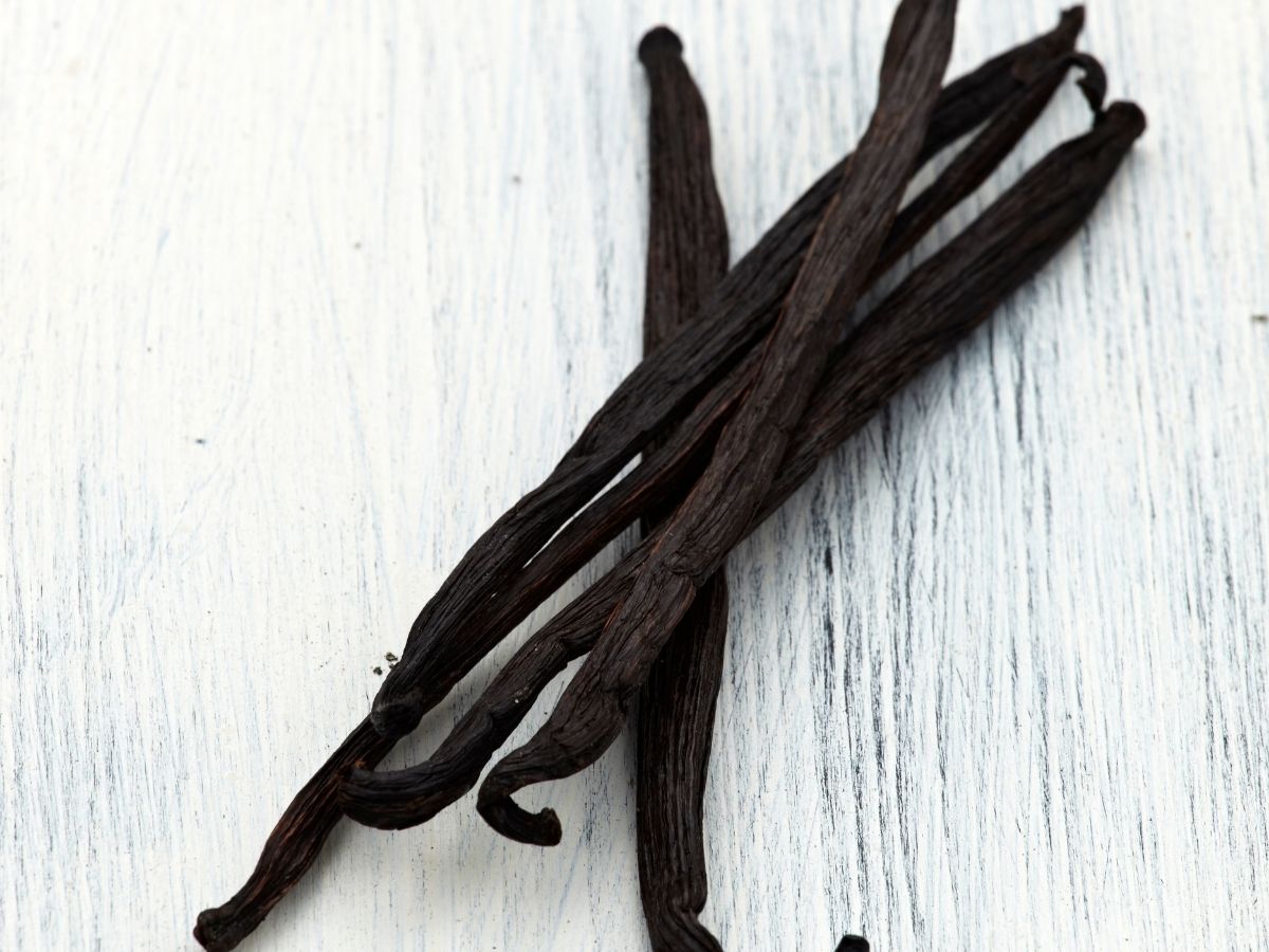 Vanilla beans on a white wooden counter. 