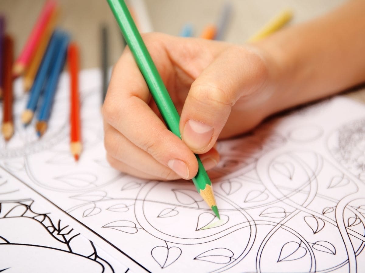 A hand coloring an adult coloring book.