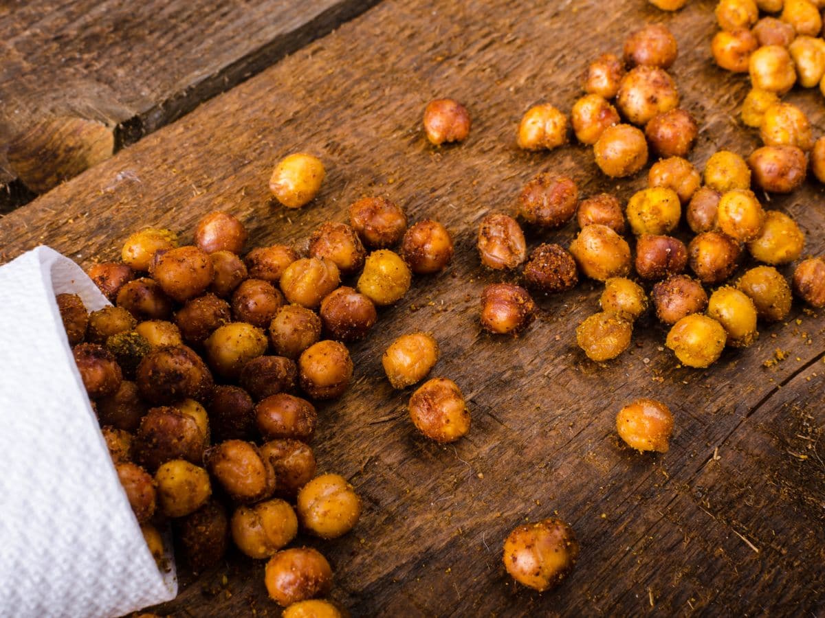 Roasted chickpeas on a wooden cutting board.