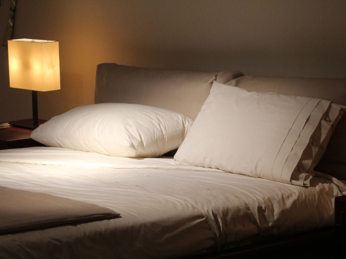 A bedroom at nighttime with a dim lamp.
