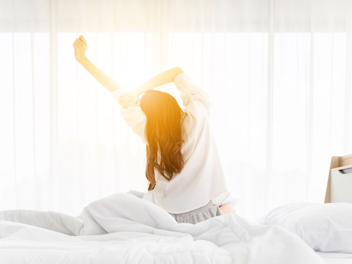 Women stretching on her bed in the morning.