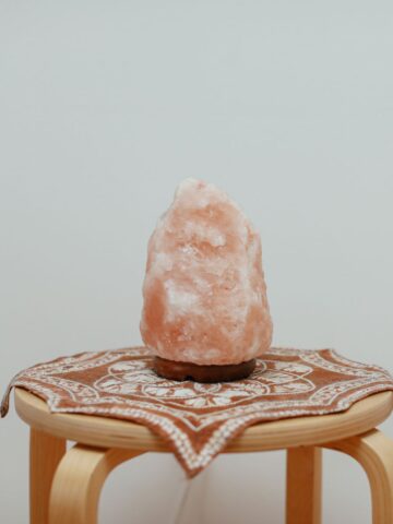 A himalayan salt lamp on a wooden table.