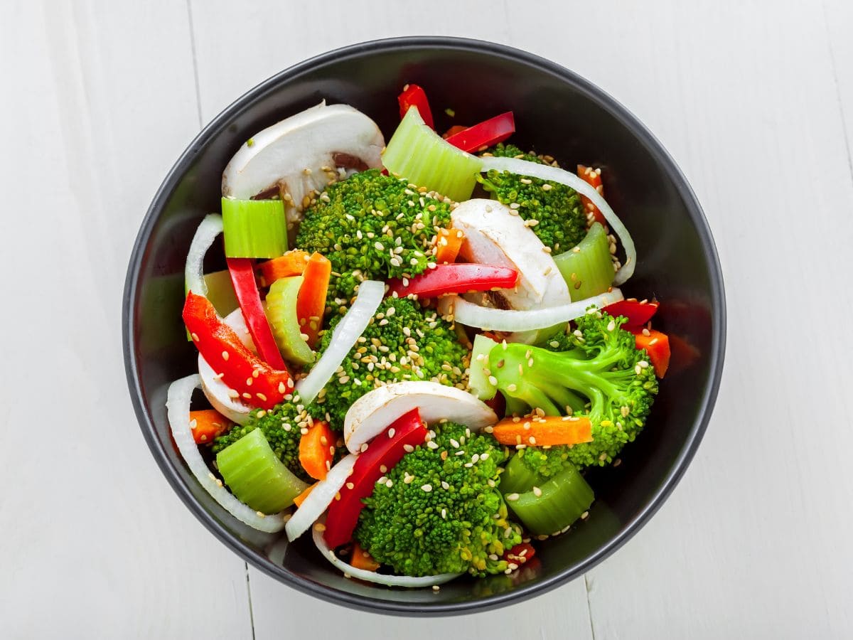 A bowl of steamed vegetables with sesame seeds on top.