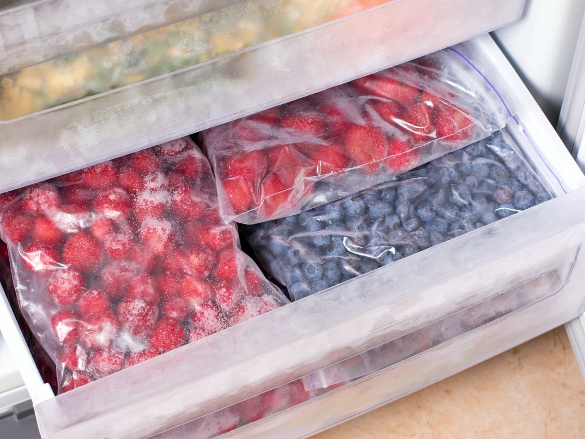 Frozen fruit in freezer bags within the freezer.