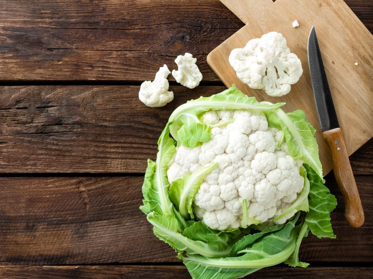 A cauliflower on a wooden table.
